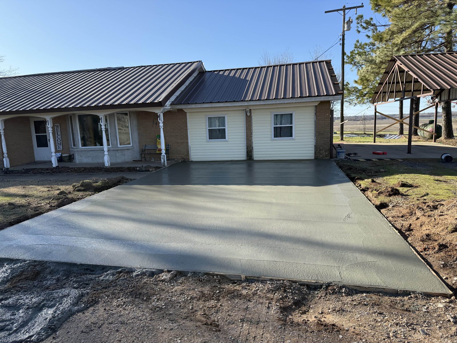 A finished concrete driveway poured up to a house.