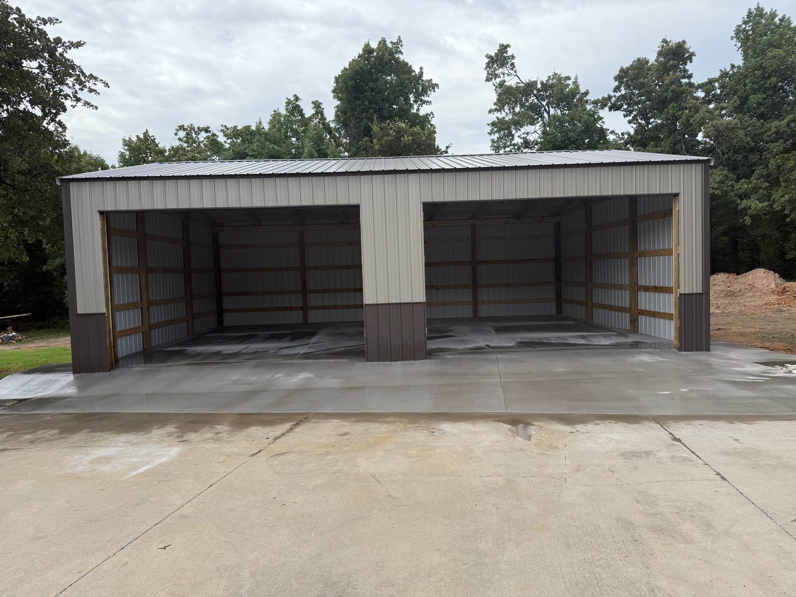 A finished concrete shop floor and apron poured under a new metal building.